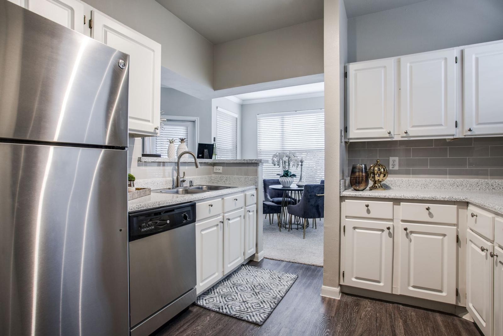 Bright kitchen with elegant, white cabinets and stainless steel appliances. 
