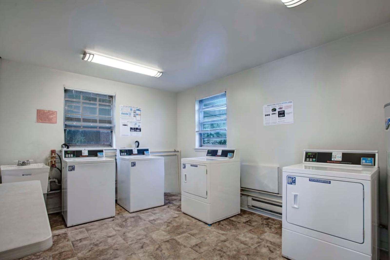 A clean and well-maintained laundry room equipped with multiple washers and dryers, ensuring hassle-free laundry days for residents.
