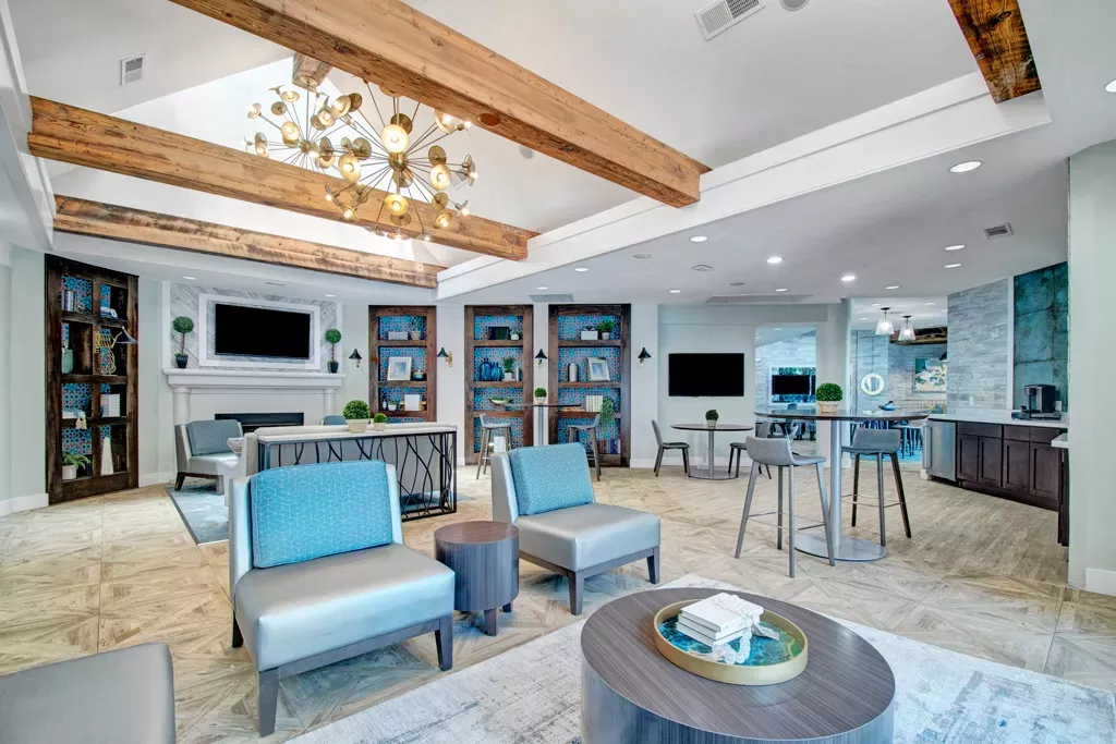 Large, upscale clubhouse with dedicated kitchen space, fireplace, and TVs for renters to come together and relax in Irving, Texas. 