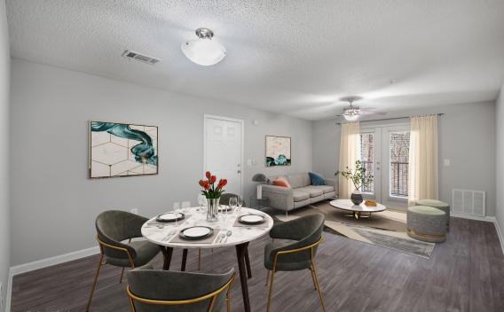  living and dining area with a modern round dining table, gray sofa, and bright decor accents under natural light.