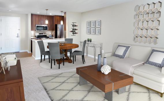 A bright and elegantly furnished living space with an open-concept kitchen, stainless steel appliances, and modern décor at The Mark at Mamaroneck.