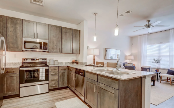 "Contemporary kitchen in an apartment at The Emerson at Forney with granite countertops, stainless steel appliances, and pendant lighting."