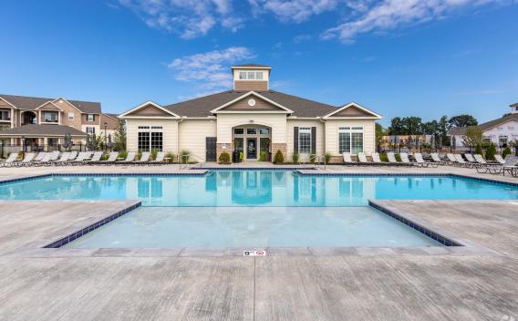 A panoramic view of the outdoor pool surrounded by lush landscaping and apartment buildings.