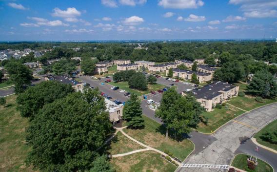 Aerial view of Forest Creek Apartments showcasing beautifully landscaped grounds, ample parking, and a serene residential community surrounded by lush greenery.