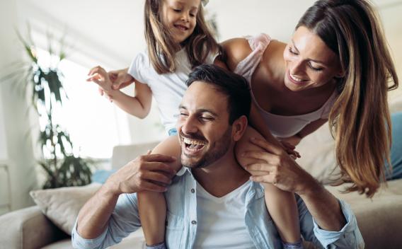 Family of three playing in a living room