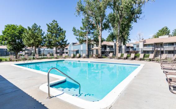 Sparkling, resort style pool with lounge chairs surrounding for residents to enjoy.