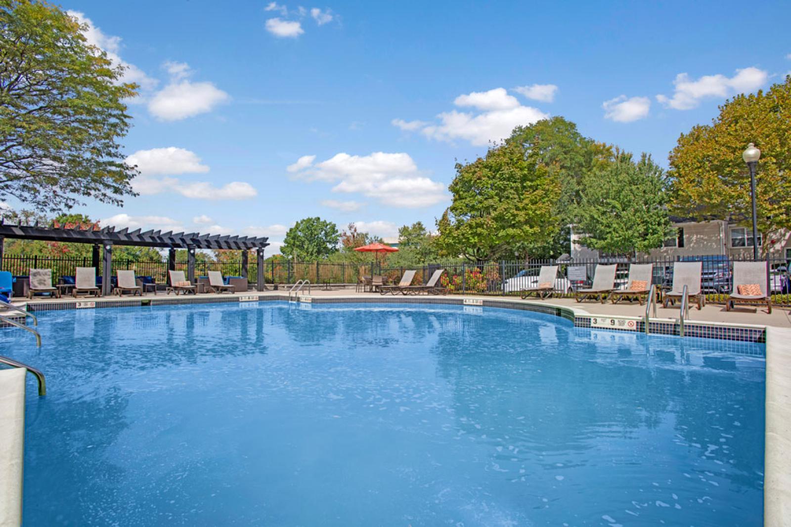Large, sparkling, resort-style pool with lounge chairs around the perimeter. 
