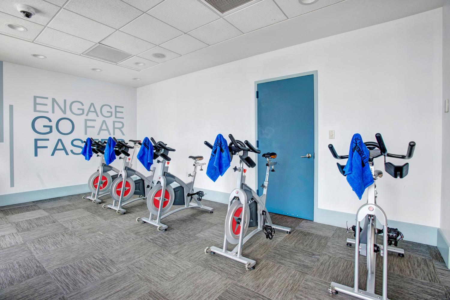 Dedicated indoor cycling studio with stationary bikes and motivational wall art.