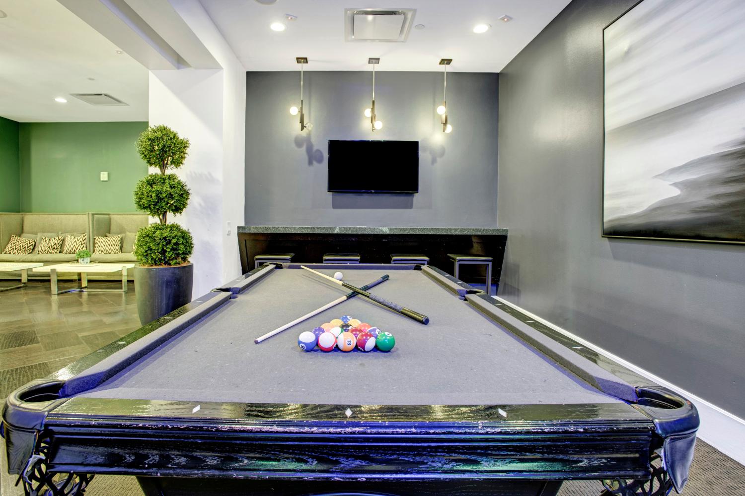 Stylish billiards room with a pool table, comfortable seating, and contemporary decor for leisure activities.