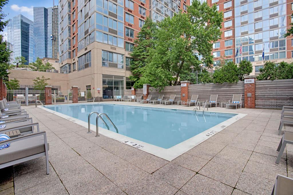 A well-maintained pool surrounded by contemporary architecture and lush landscaping for residents to relax.