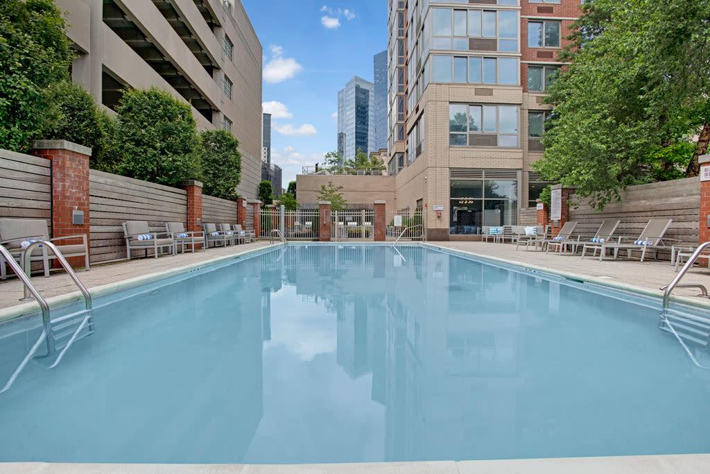 A well-maintained pool surrounded by contemporary architecture and lush landscaping for residents to relax.