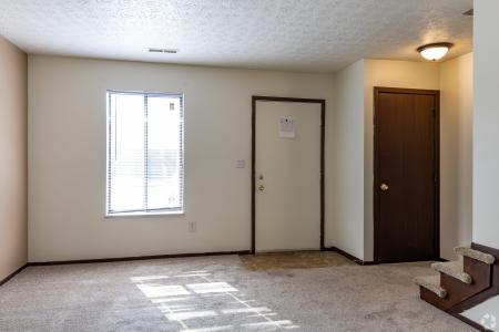 A spacious living room with plush seating and a dining area, showcasing the cozy and welcoming interiors of North River Place Apartments
