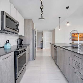 Fully equipped kitchen featuring modern appliances, an elegant backsplash, and a spacious layout in Parkline Miami luxury apartments.