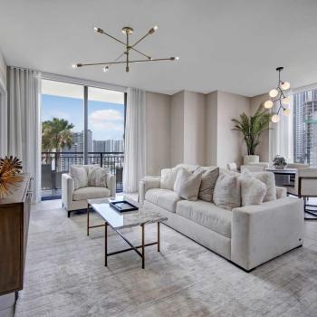 Bright living room with plush furniture, contemporary decor, and access to a private balcony overlooking the Miami skyline in Parkline Miami.
