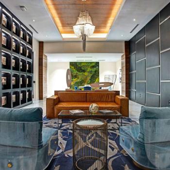 A luxurious seating area in the lobby of Parkline Miami Luxury Apartments, featuring designer furniture, warm lighting, and a vertical greenery accent wall.