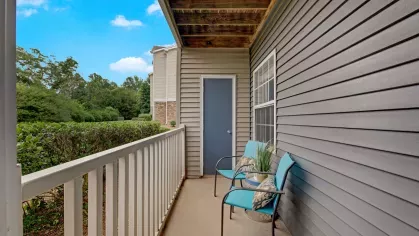  Private balcony with cozy seating, surrounded by greenery and featuring a peaceful view, offering a relaxing outdoor space for residents to unwind.