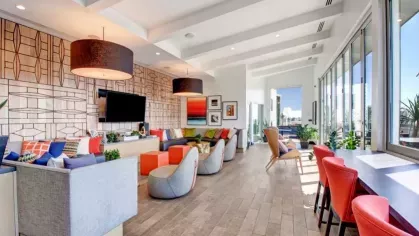 Stylish lounge with comfortable seating, a large TV, and a vibrant mix of colors and textures.