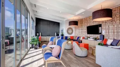 Contemporary rooftop lounge with bold decor, natural light, and patio access.