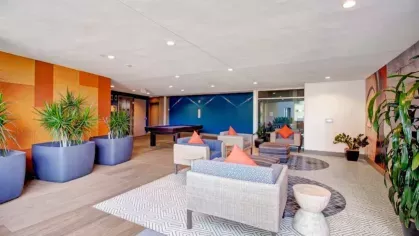 Relaxation space with casual seating, plants, and a pool table in a modern environment.