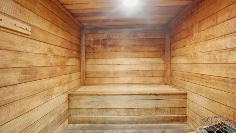 A warm, inviting sauna with wooden benches and walls, creating a relaxing space for unwinding and rejuvenation.