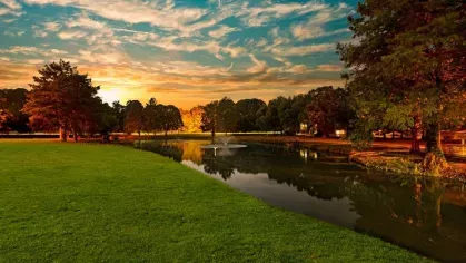 A tranquil lake reflecting the warm colors of a sunset.