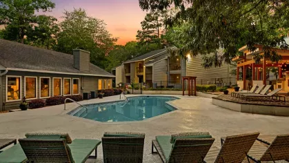 Evening poolside ambiance with lit seating areas and a serene atmosphere.
