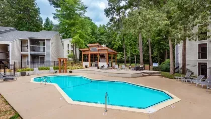 Scenic poolside view showcasing a seating pavilion and lush greenery.