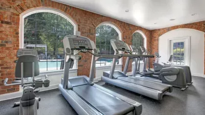Fitness center with treadmills overlooking an outdoor pool.