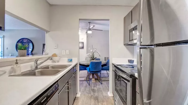 Another angle of a modern kitchen with stainless steel appliances, offering a clear view of the dining area in the background.