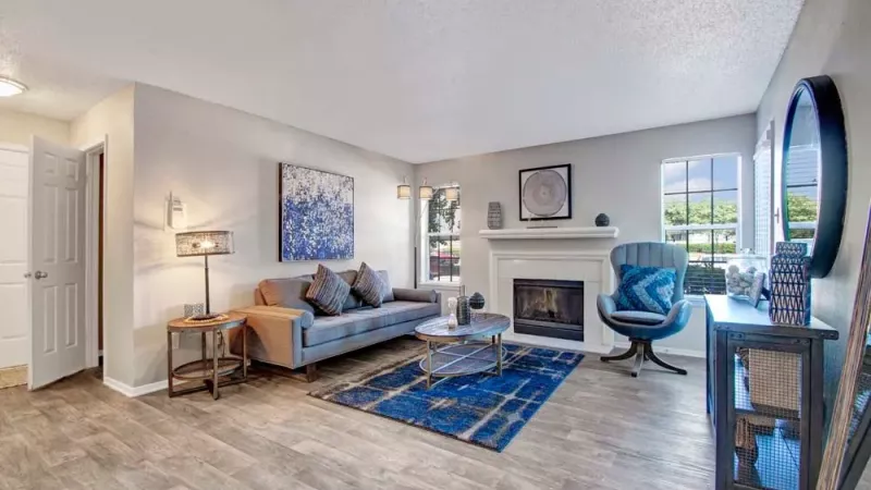 Well-lit gym space with exercise machines, dumbbells, and a treadmill, featuring large windows and mirrors.