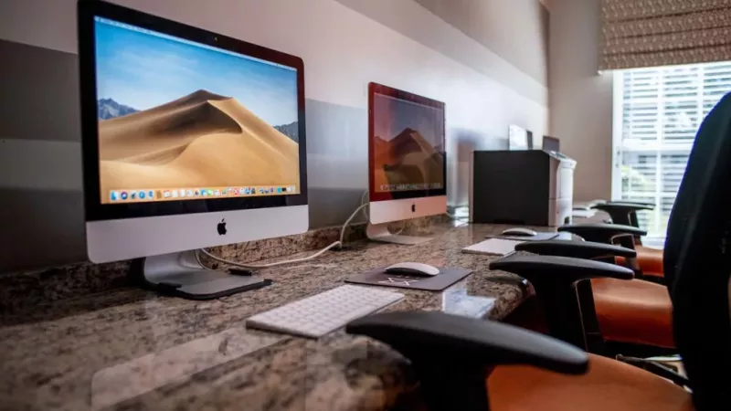A spacious gym featuring various exercise equipment, including treadmills and machines, surrounded by walls and a ceiling. The floor is designed for fitness activities.