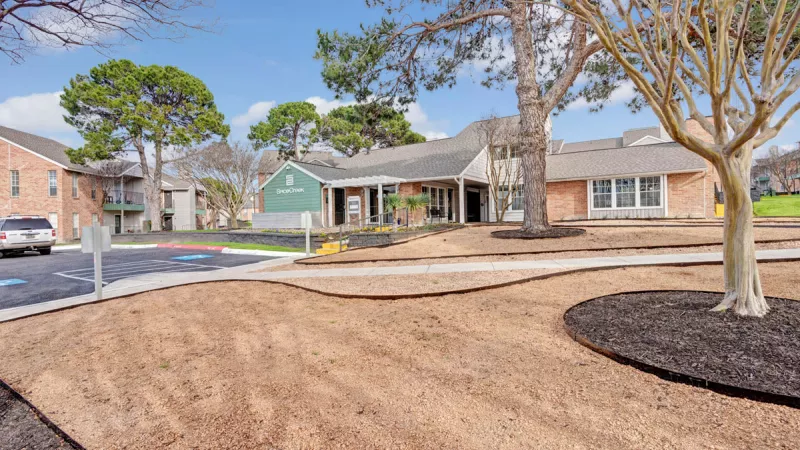  Community outdoor area with landscaped pathways, mature trees, and well-maintained apartment buildings, creating a peaceful and inviting environment for residents.
