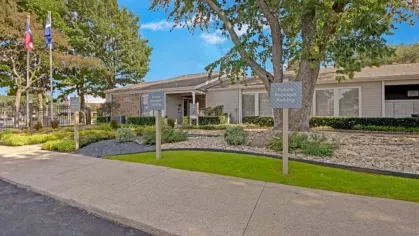 A leasing office with a welcoming entrance, trees, and designated parking for future residents.