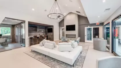 A luxurious resident lounge with a fireplace, soft couches, and a contemporary open floor plan.