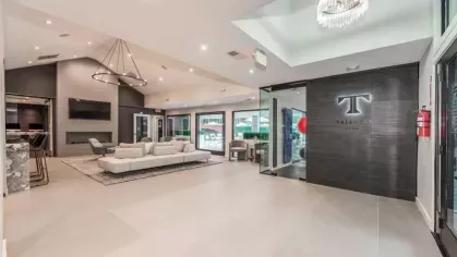 A sophisticated entrance to the resident lounge, featuring the community's branded sign and elegant decor.