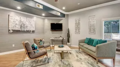 A contemporary lounge area with comfortable seating, a television, and chic wall art.