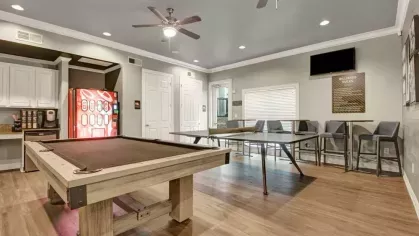 A recreational room with a pool table, ping pong table, and vending machines.