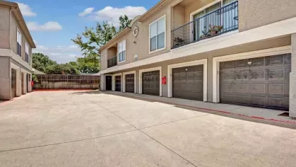 A row of garage doors beneath residential units, providing convenient parking options.