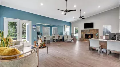 A welcoming clubhouse with comfortable seating, a fireplace, and computer stations, highlighted by modern decor and open spaces.