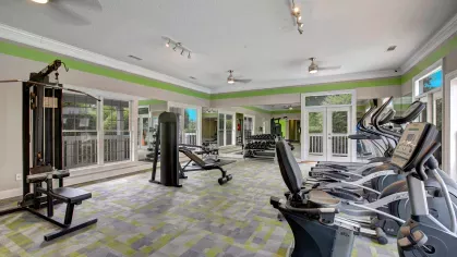 A modern fitness center filled with cardio and strength-training equipment, accented by vibrant colors and natural light.
