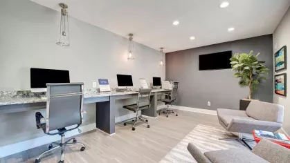 A sleek computer lounge with individual workstations, gray chairs, and a minimalist aesthetic.