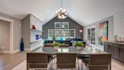 A spacious clubhouse with high ceilings, a dining area, and vibrant decor complementing the outdoor view.