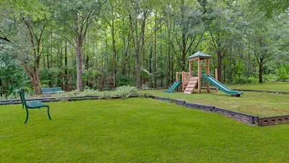A serene playground set amidst lush greenery, offering a peaceful play area for children.