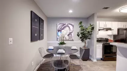 A dining area with a black round table, stylish chairs, and artistic wall decor.