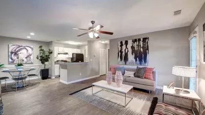 A spacious living room with a sofa, coffee table, and elegant modern artwork.