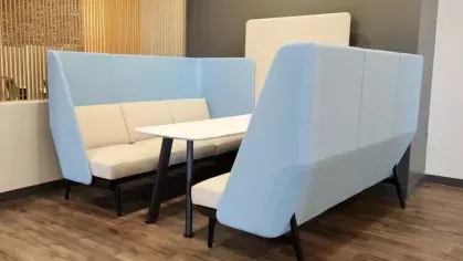 A private seating booth with cushioned benches and a sleek white table in a contemporary setting.