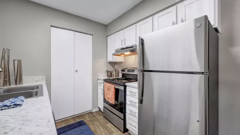 A modern kitchen with stainless steel appliances and white cabinets featuring a sleek, clean design.
