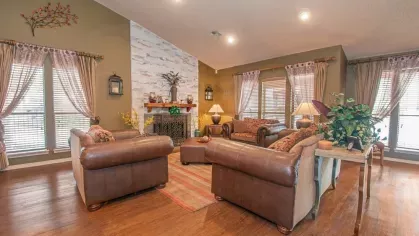 A close-up of a kitchenette area in the clubhouse featuring dark wood cabinetry, a microwave, and a mini-fridge.