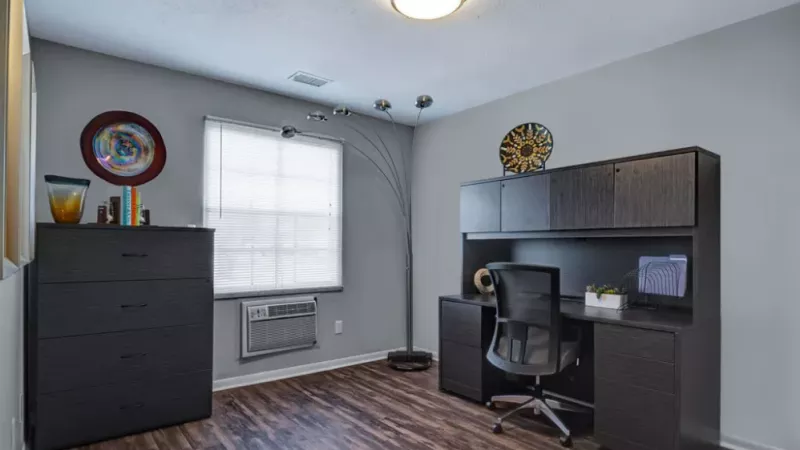 A functional home office space with a desk, chair, and vibrant wall art.