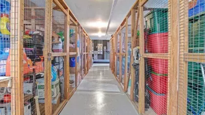 A storage facility with secure, fenced lockers filled with personal belongings.